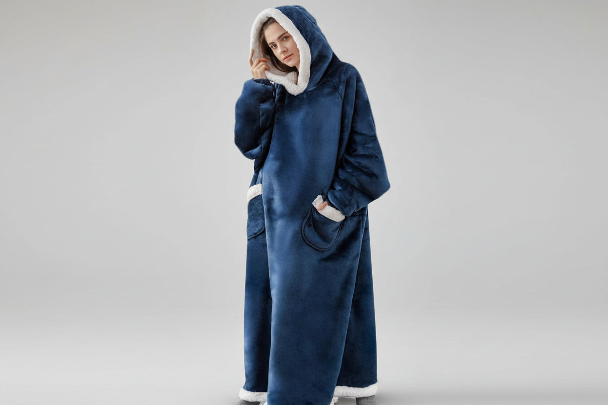 Person wearing a blue hooded blanket with white trim on a white background