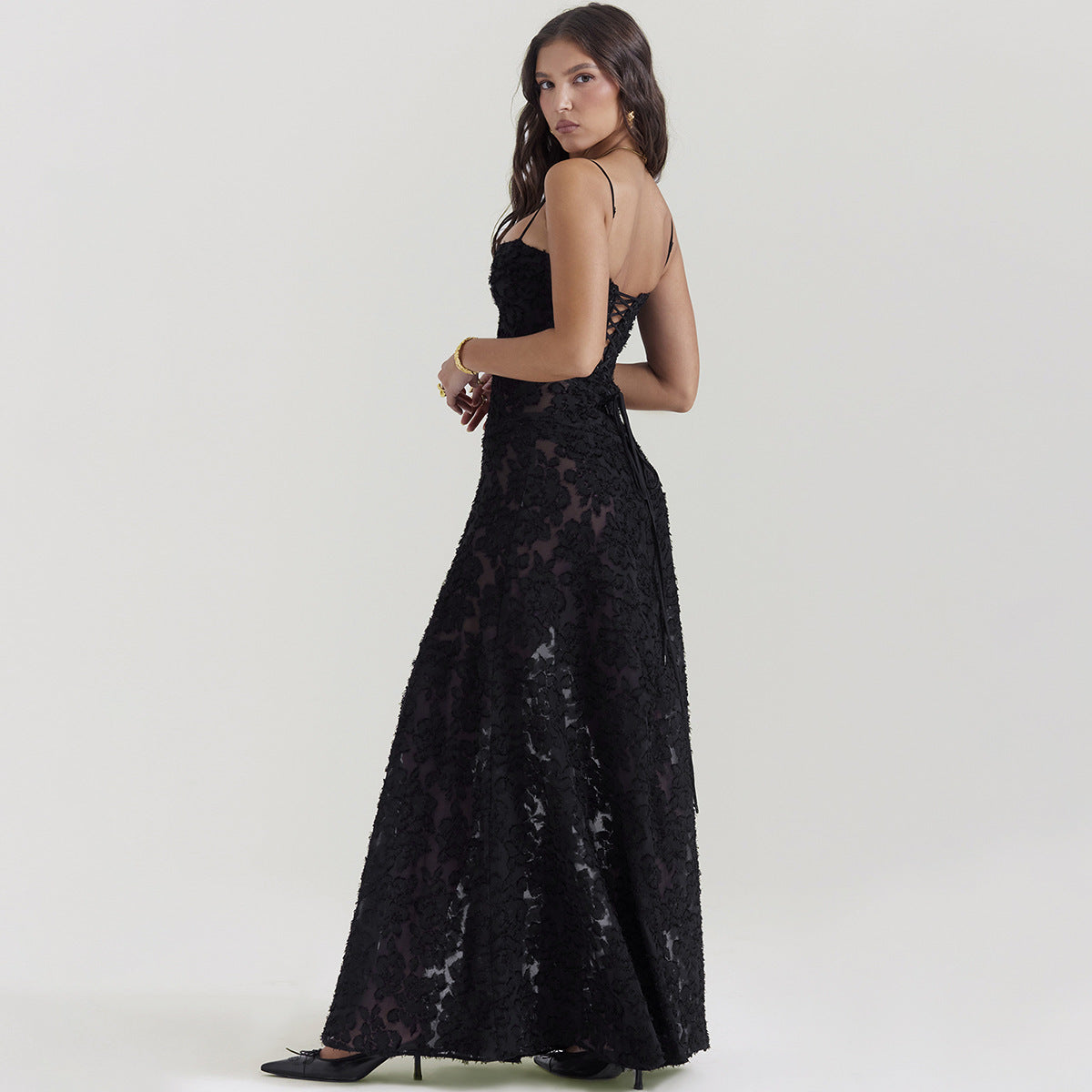 Woman wearing a black lace evening gown on a white background