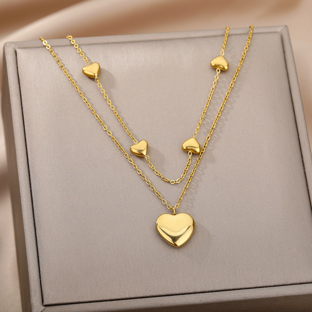 Gold heart-shaped necklace on a gray jewelry box