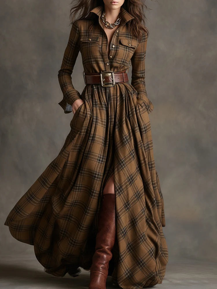 Woman wearing a long brown plaid dress with a belt and boots against a gray background