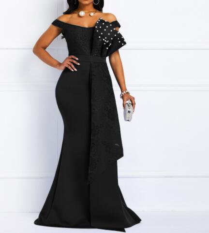 Black off-shoulder evening gown with pearl embellishments on a white background