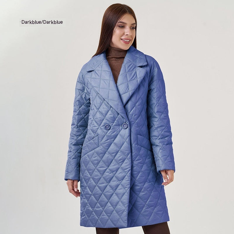 Woman wearing a blue quilted coat on a light gray background