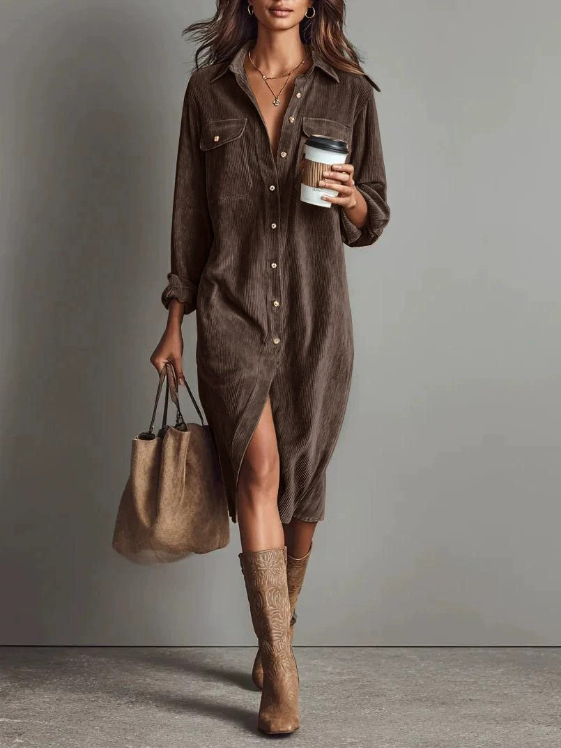Woman wearing a brown dress and boots, holding a handbag and a coffee cup against a gray background