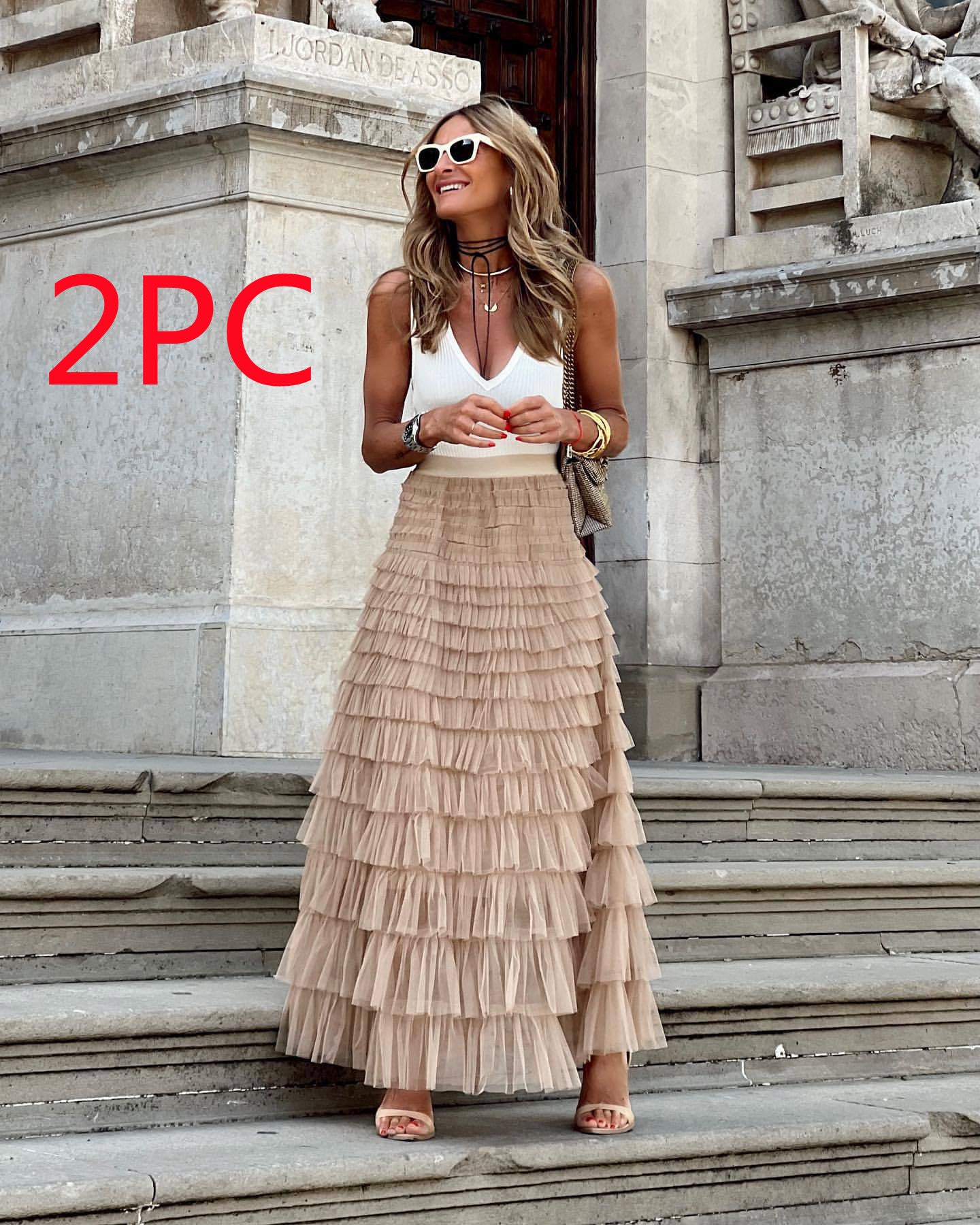 Woman in a layered skirt standing on steps with '2PC' text in red.
