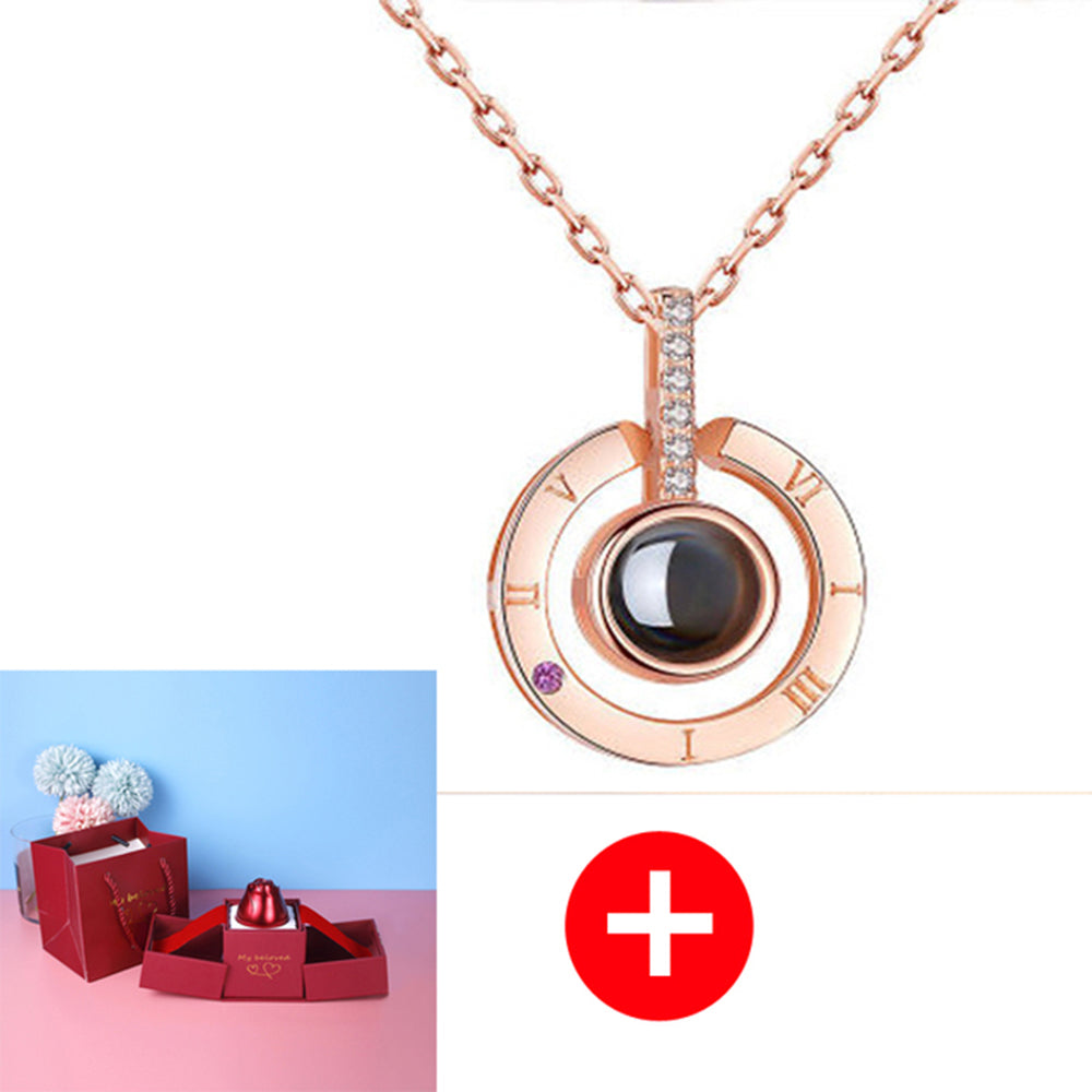 Rose gold necklace with black gemstone and diamond accents on a white background, with a red plus sign and small gift box inset.