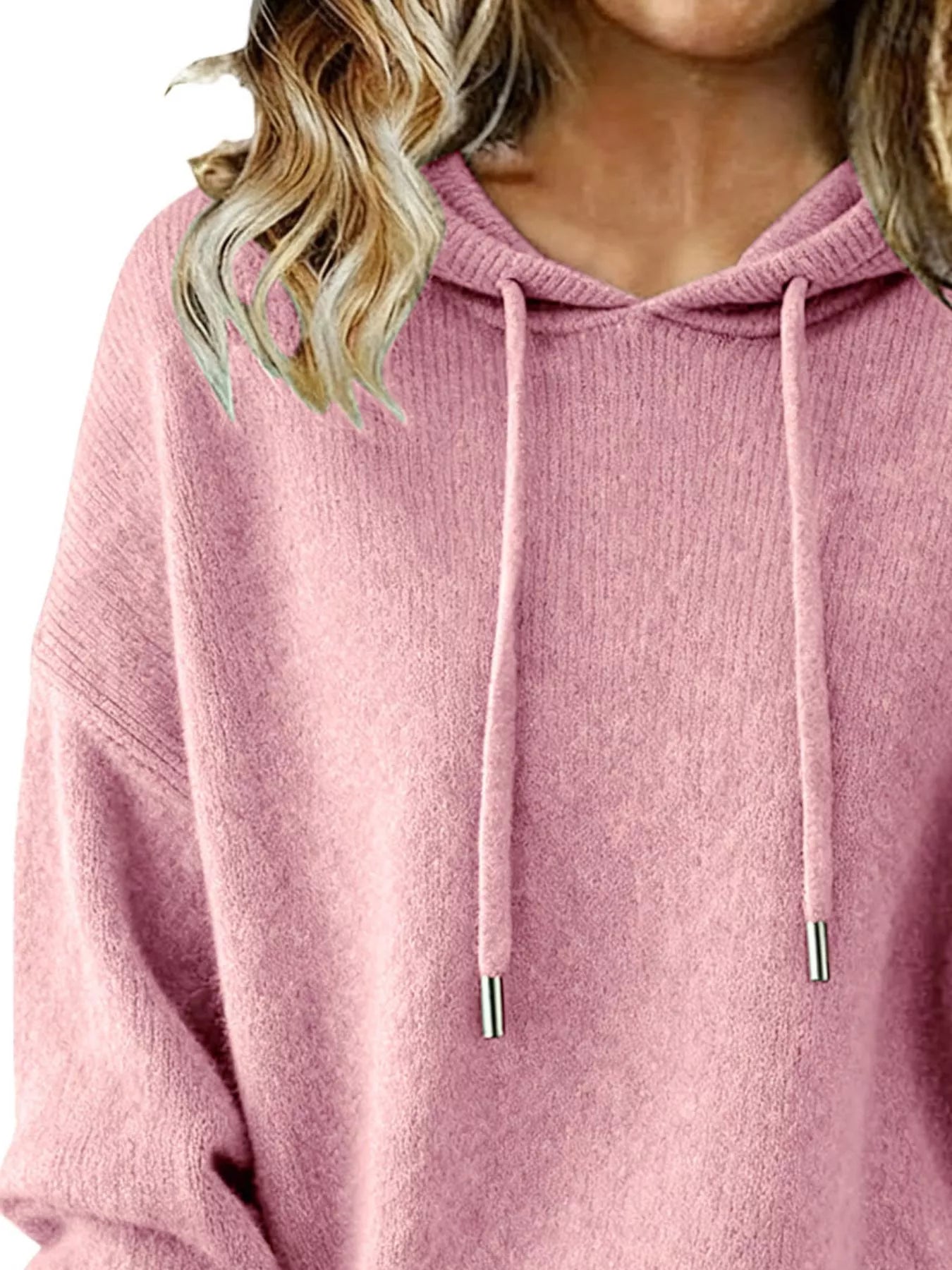Close-up of a pink hoodie worn by a person with blonde hair.