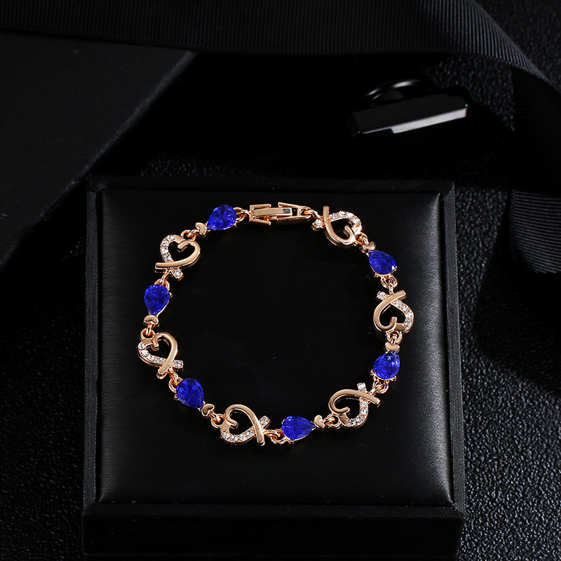 Gold bracelet with blue stones on a black box