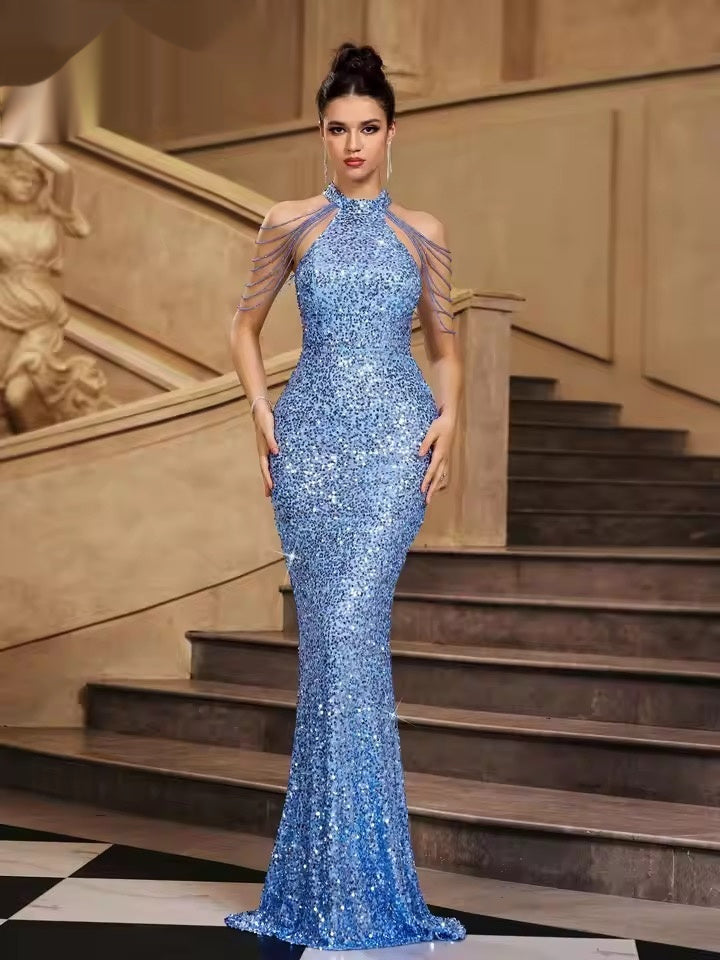 Woman in a blue sequin dress standing on a staircase
