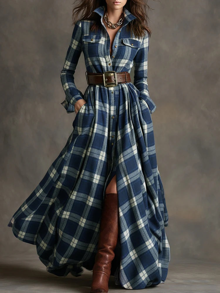 Woman wearing a long blue plaid dress with a belt and brown boots on a gray background