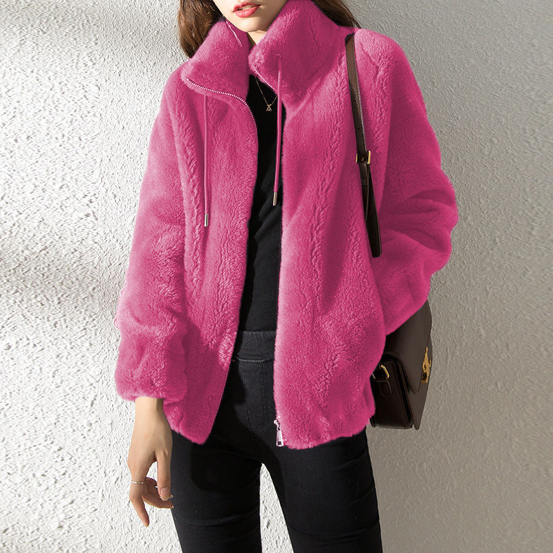 Person wearing a bright pink jacket with a plain background