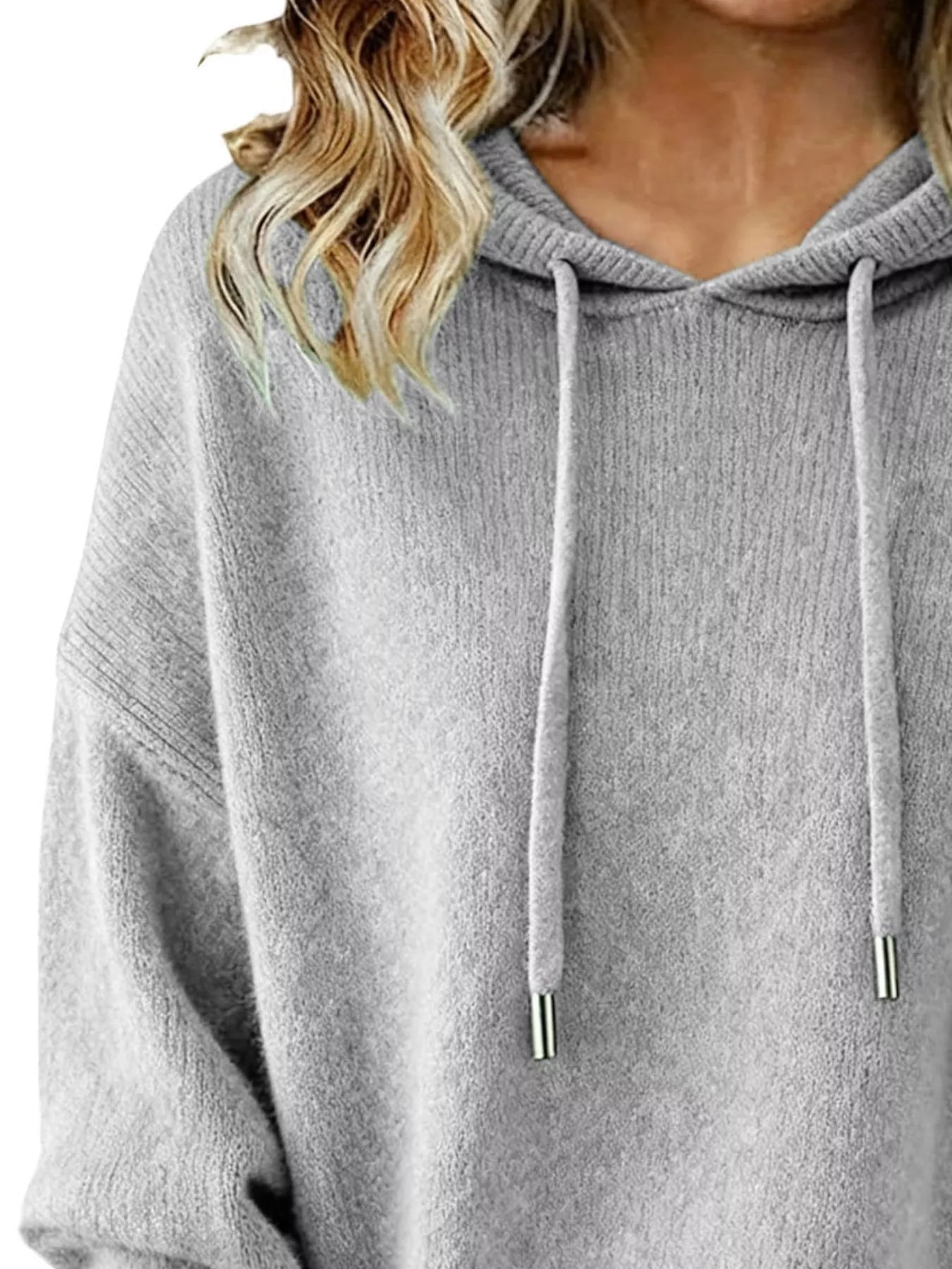 Gray hoodie worn by a person with blonde hair, close-up view.