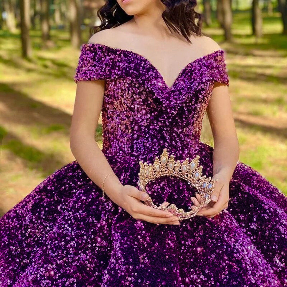 Person wearing a sparkling purple dress holding a tiara in a park setting