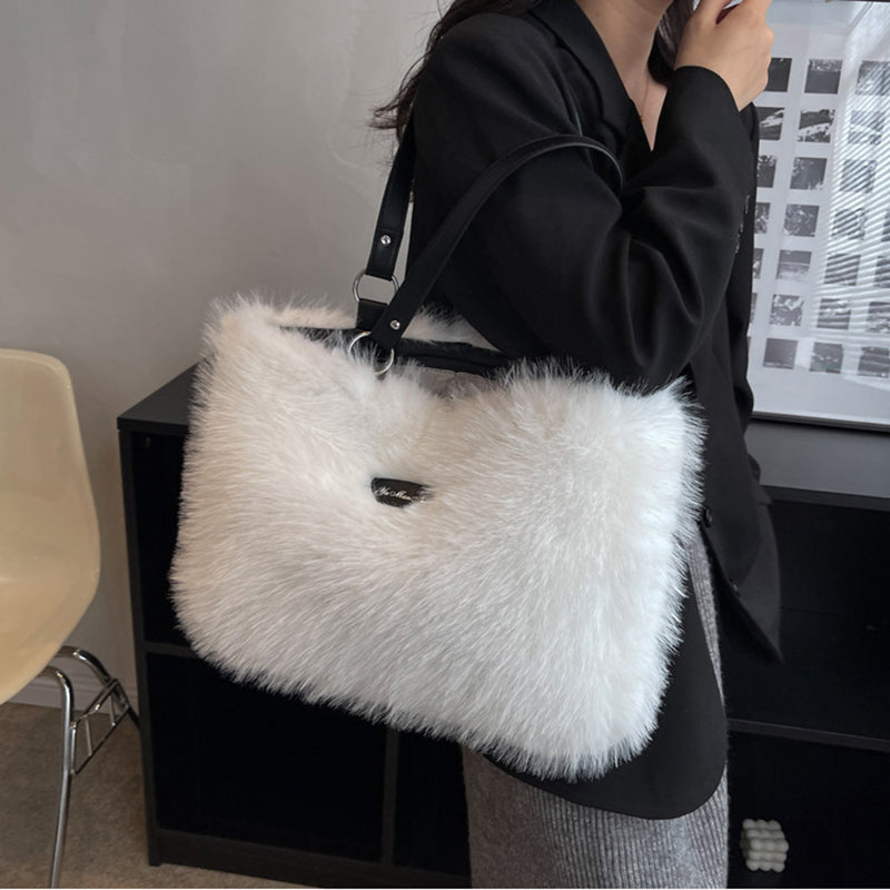 Person holding a white fluffy handbag indoors