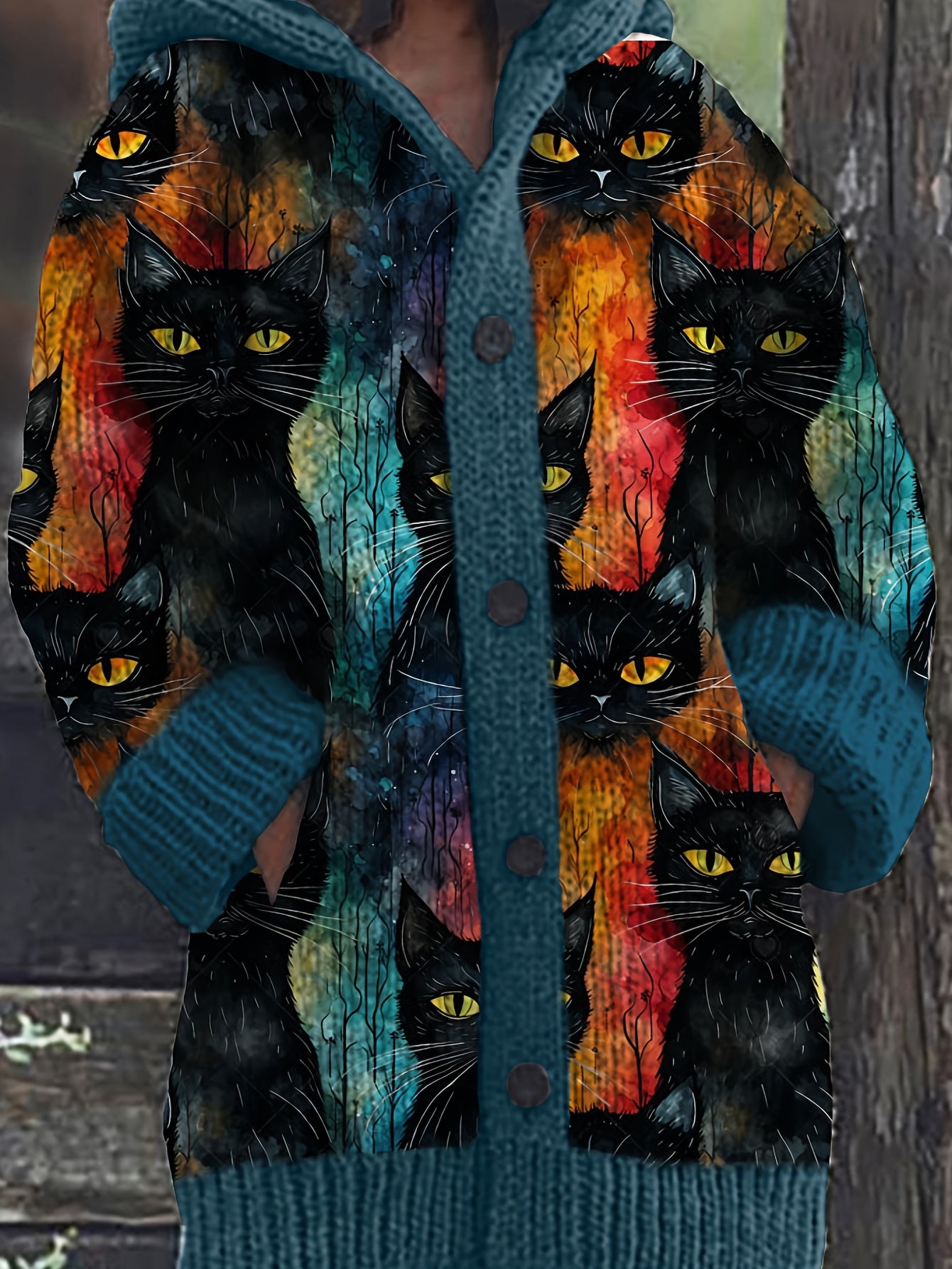 Cardigan with black cat design on a wooden background