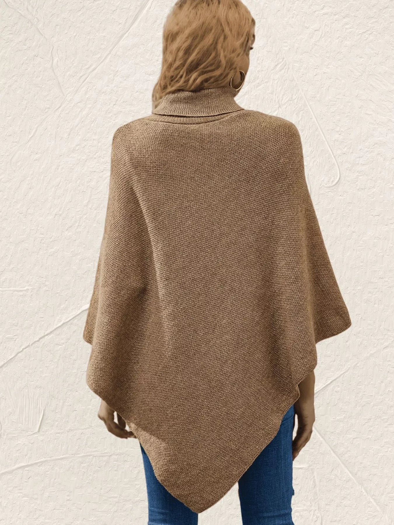 Person wearing a brown poncho over a plain background