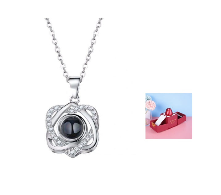 Silver necklace with a black pendant on a white background