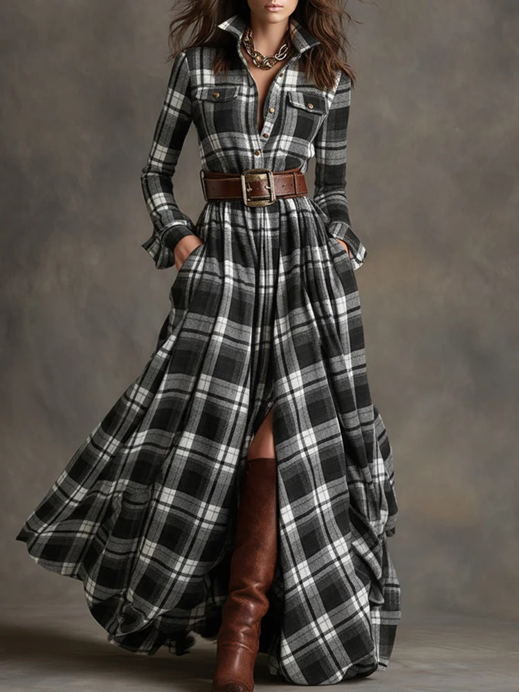 Woman wearing a long plaid dress with a belt and brown boots against a gray background