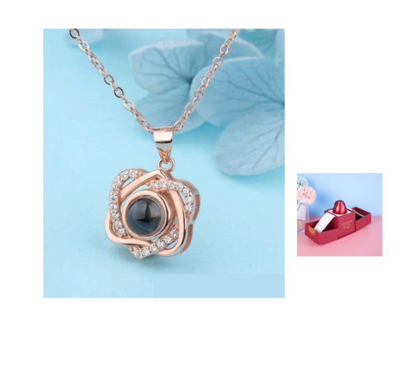 Rose gold necklace with black pendant on a light blue background