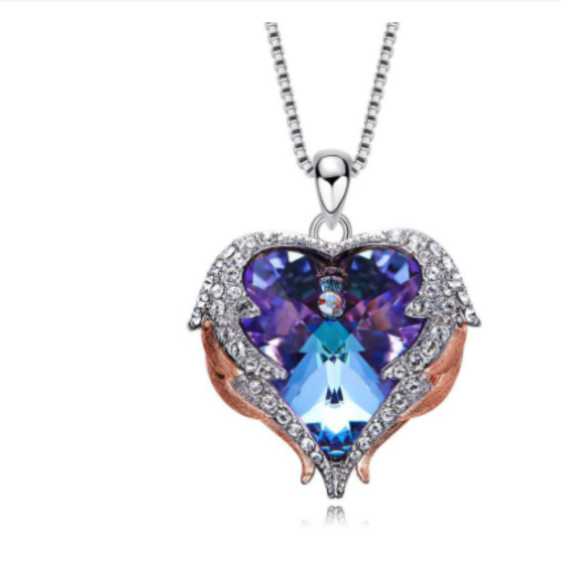 Heart-shaped pendant with blue gemstone on a white background