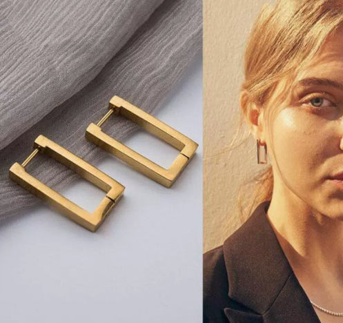 Gold hoop earrings on a textured surface with a close-up of an ear wearing one.