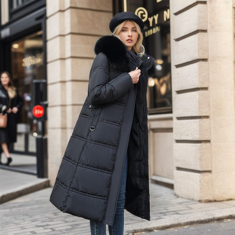 Woman wearing a black puffer coat with fur hood on a city street.