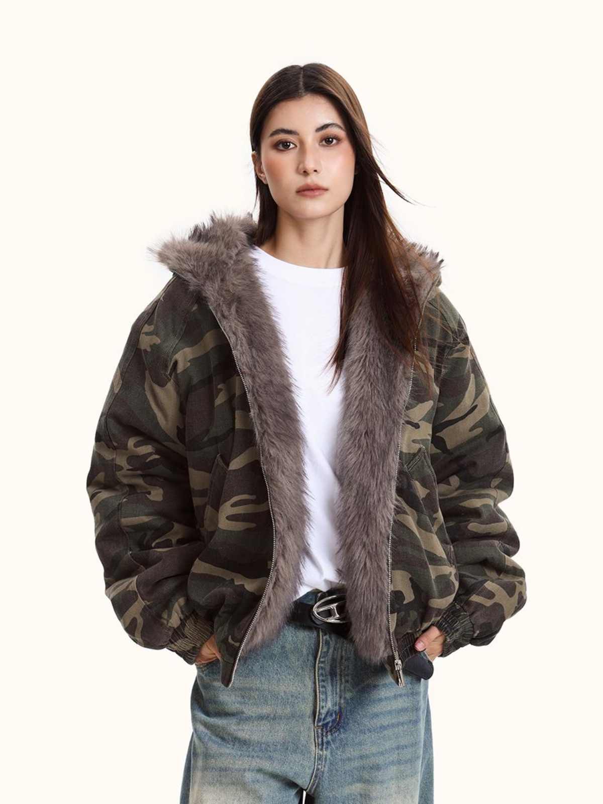 Person wearing a camouflage jacket with fur lining on a white background