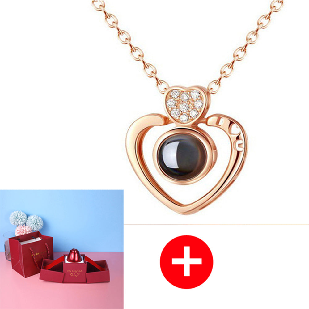 Rose gold heart-shaped necklace with a dark gemstone on a white background